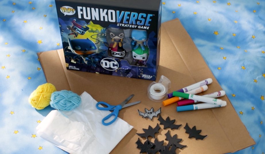 Funko Pop! Funkoverse Strategy Game: DC Comics, plastic bag with handles, cardboard, Markers, children’s craft scissors, yarn, tape, stickers